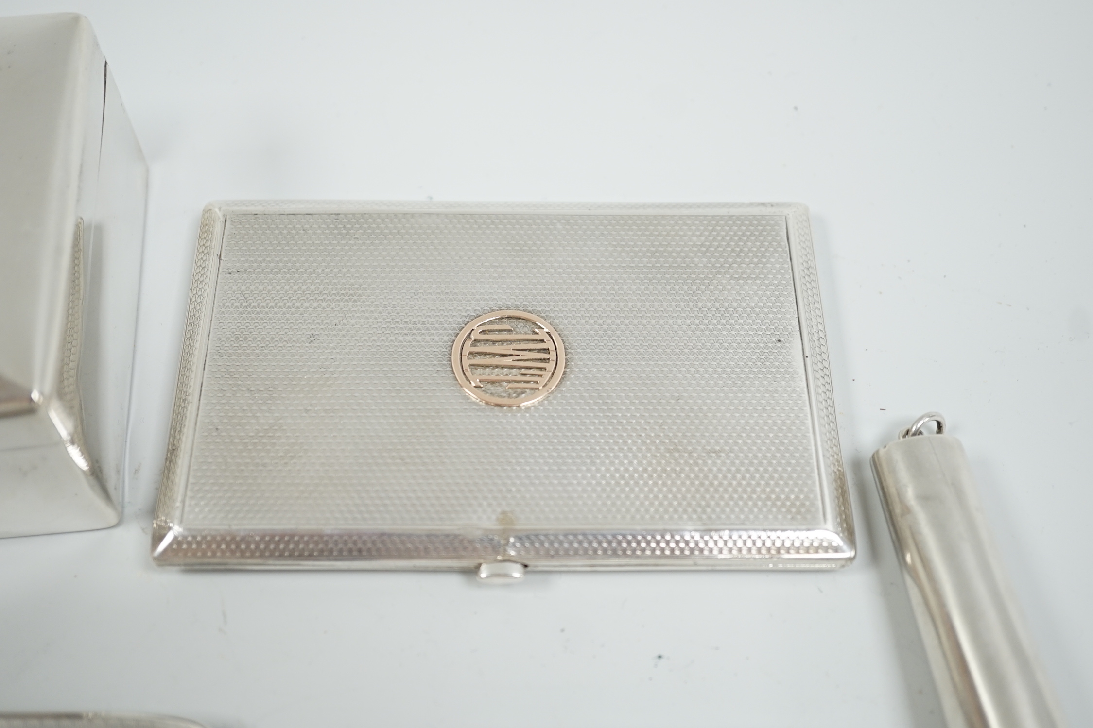 A George V silver mounted cigarette box, 10.5cm, three assorted engine turned silver cigarette cases and a silver cheroot case.